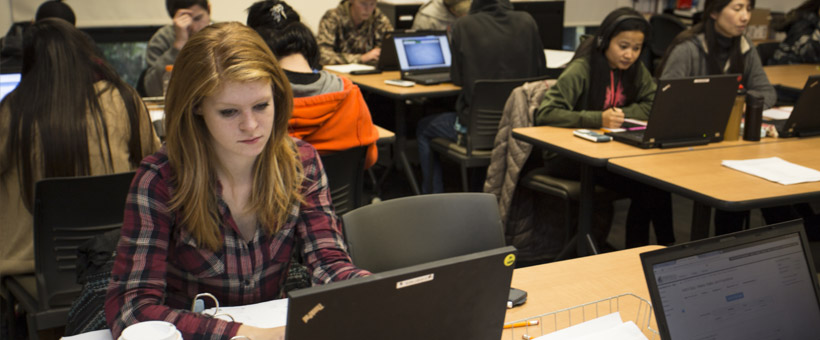 Students in classroom studying with laptops